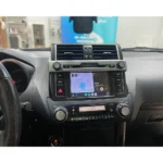 Toyota Land Cruiser dashboard with Apple CarPlay displaying navigation and music.